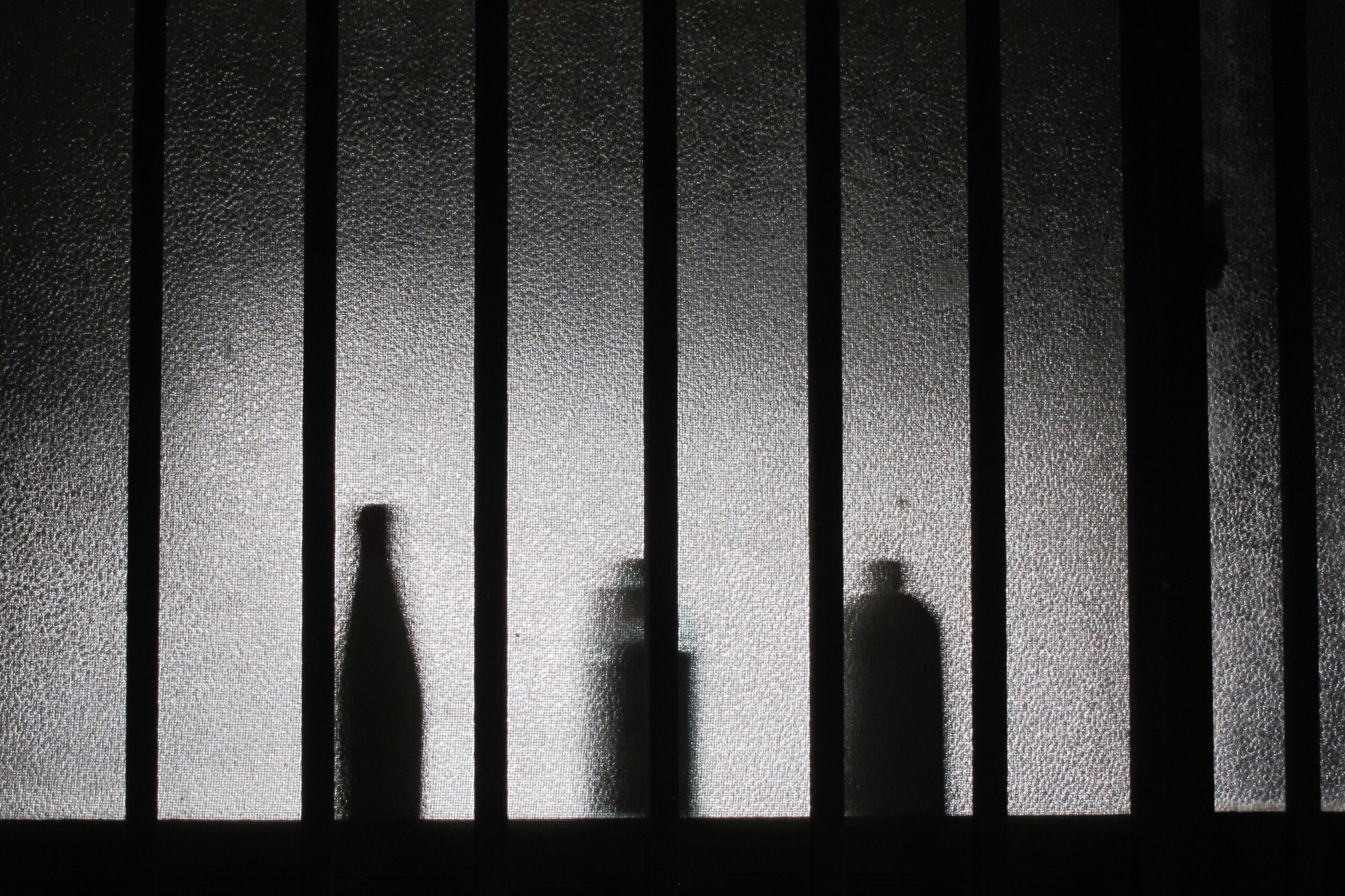 Silhouette of bottles through a frosted glass window