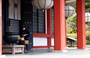 Woman lighting incense outside a temple