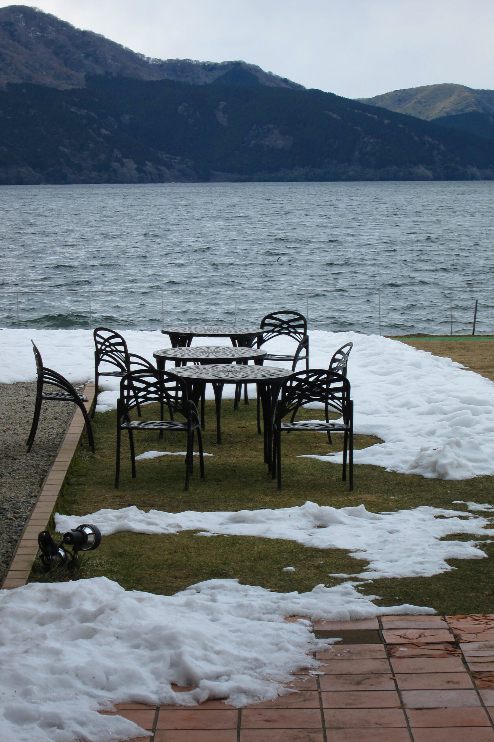 Table and chairs by the lakeside, in snow